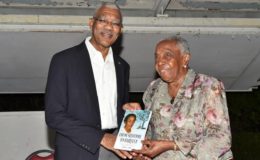 Carmen Jarvis presenting a copy of her autobiography to President David Granger. (Ministry of the Presidency photo)