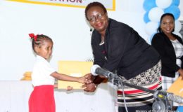 Glenna Vyphuis, Chief School’s Welfare Officer making a presentation to one of the children. (Ministry of Education photo)