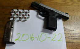 The gun and live ammunition that were found by the police on the trio. (Police photo)