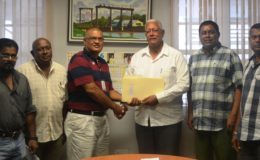 Agriculture Minister Noel Holder (third from right) receiving the plan from Gobin Harbhajan, the Prime Minister's representative. (Ministry of Agriculture photo)