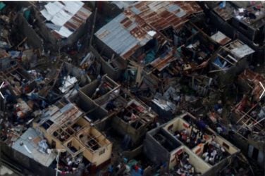 People walk next to destroyed houses after Hurricane Matthew passes Jeremie, Haiti. REUTERS/Carlos Garcia Rawlins