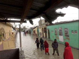 People wade through a flooded street while Hurricane Matthew passes, in Cite-Soleil in Port-au-Prince, Haiti, October 4, 2016. REUTERS/Carlos Garcia Rawlins