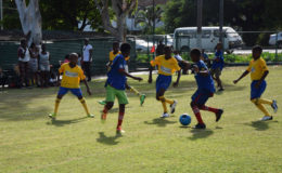 On the attack-J.E. Burnham forwards (blue) making a rare attacking foray into the defensive third of West Ruimveldt during their matchup in the 5th annual Court’s Pee-Wee Primary Schools football championships continued yesterday at Thirst Park.
