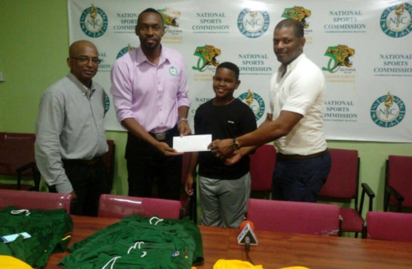 Director of Sport Christopher Jones hands over the cheque to GTTA president Godfrey Munroe while Kaysan Ninvalle and Linden Johnson look on.