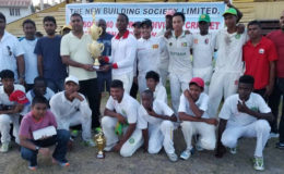 Captain Keon De Jesus smiles as he collects the winning trophy from NBS Berbice Manager Rana Persaud in the presence of his teammates, BCB officials and staff of NBS.