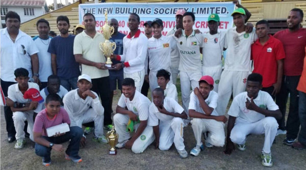 Captain Keon De Jesus smiles as he collects the winning trophy from NBS Berbice Manager Rana Persaud in the presence of his teammates, BCB officials and staff of NBS.