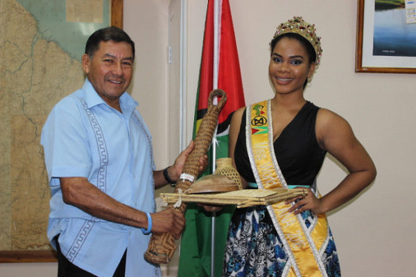 Minister of Indigenous Peoples Affairs Sydney Allicock presenting the Indigenous craft to Miss World Guyana Nuriyyih Gerard.  