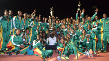 The GDF track and field outfit posing with the  Inter Services Annual Athletic Championship Trophy last night at the National Track and Field Centre.  