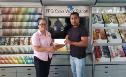 Janet Alphonso (left) of Bumper to Bumper
present sponsorship cheques to the show’s organizer, Videsh Sookram.