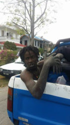 One of the suspects after he was caught and placed behind a police pick-up.