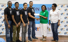 Team leader and CEO of V75 Eldon Mark receiving the first prize cheque for $300,000 from Minister of Public Telecommunications Catherine Hughes at the recently concluded Hackathon.
