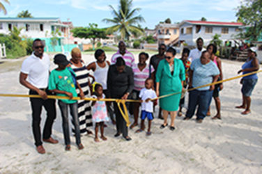 Minister within the Ministry of Education Nicolette Henry (third, right in front), Georgetown Mayor Patricia Chase-Green (second, right) and Director of Sport Christopher Jones (far left) flanked by residents of Guyhoc Park as the ribbon is cut for official commissioning yesterday. (Photo by Keno George) 