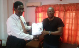 Vice chairman of the referee/judges commission, Elton Chase receiving the     donation from GBA’s president, Steve Ninvalle.
