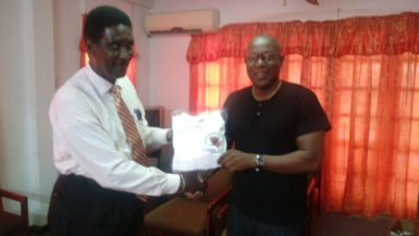 Vice chairman of the referee/judges commission, Elton Chase receiving the     donation from GBA’s president, Steve Ninvalle. 