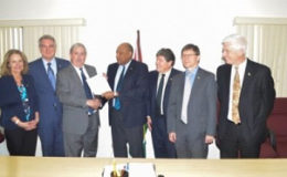 Minister of Natural Resources Raphael Trotman (centre) receives the letter of notification from Jeff Simons, Country Manager of Exxon Mobil along with representatives from Nexen Energy and Hess Corporation at the Ministry of Natural Resources Boardroom, Brickdam (GINA photo)
