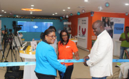 Minister of Public Telecommunications, Cathy Hughes (left) and CEO of GTT Justin Nedd (right) during the ceremonial cutting of the ribbon to launch the new GTT Customer Experience store on Brickdam.
