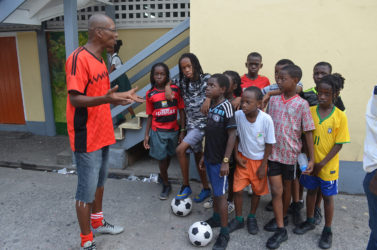 Getting the point across-Head Coach Oscar Payne (left) discussing the final aspects of his tactical plan with the St. Angela’s squad during a training session at the school’s compound ahead of their clash with neighbours St. Agnes. (Orlando Charles photos)