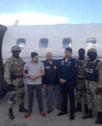 Efrain Antonio Campo Flores (2nd from L) and Franqui Fancisco Flores de Freitas stand with law enforcement officers in this November 12, 2015 photo after their arrest in Port Au Prince, Haiti. Courtesy of U.S. Attorney’s Office Manhattan/Handout via REUTERS