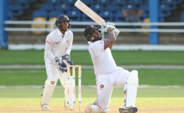 Wicketkeeper Mario Rampersad watches as Roshon Primus clears the ropes for one of his five sixes during his top score of 65 for T&T Red Force on Saturday. (Photo courtesy WICB Media)
