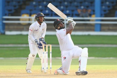 Wicketkeeper Mario Rampersad watches as Roshon Primus clears the ropes for one of his five sixes during his top score of 65 for T&T Red Force on Saturday. (Photo courtesy WICB Media)