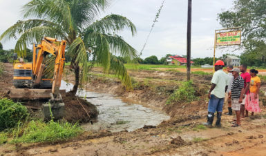 Vice-chairman of the NDC Linden Fowler and Chairman of the Works Committee Fizul Ghani (first and second left) examine the work along with residents