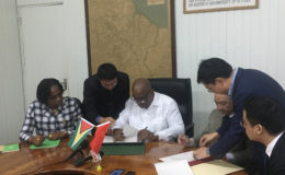 Minister of Finance Winston Jordan (third from left) signing the agreement yesterday with Chinese Ambassador to Guyana Zhang Limin (third from right). Looking on are Minister within the Ministry of Public Infrastructure Annette Ferguson (left) and Chinese and local officials. 