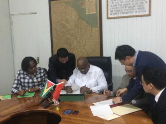 Minister of Finance Winston Jordan (third from left) signing the agreement yesterday with Chinese Ambassador to Guyana Zhang Limin (third from right). Looking on are Minister within the Ministry of Public Infrastructure Annette Ferguson (left) and Chinese and local officials. 