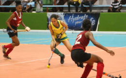 Latacia Chung (centre) of Hikers on the attack during her hat-trick effort against Old Fort at the National Gymnasium in the Diamond Mineral Water International Indoor Hockey Festival