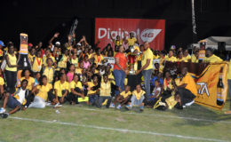 Athletes and officials of Upper Demerara/Kwakwani celebrating last night at the National Stadium with their Champions of Champions trophy which was presented by Digicel’s Louanna Abrams. (Orlando Charles photo) 
