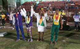 Ira Lewis, popularly known as ‘Lady Ira’ raises the hands of some of the athletes who received racing watches following last night’s National Schools Cycling, Swimming and Track and Field Championships.
