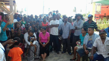 Bibi Aziz, the mother of slain carpenter Faiyaz Narinedatt, seated at centre in pink with other villagers who turned out to listen to Minister of Public Security, Khemraj Ramjattan on Saturday.