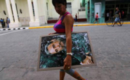 A woman carries a portrait of Cuba’s late President Fidel Castro in Santa Clara, Cuba, November 30, 2016. REUTERS/Ivan Alvarado
