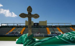 A cross is pictured over a flag of Chapecoense soccer club atop an altar prepared to a mass in tribute to their players at the Arena Conda stadium in Chapeco, Brazil November 30, 2016. REUTERS/Ricardo Moraes