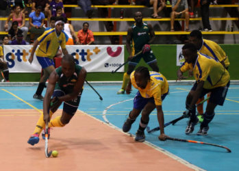 Hikers Aroydy Branford (green) trying to maintain possession of the ball amid the pressure from several players of the National Junior Men’s Team during their first division semi-final at the National Gymnasium  Saturday.