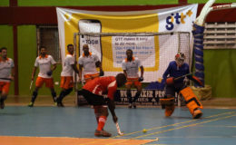 Old Fort’s Askofu Simon (red) in the process of unleashing a strike from a penalty corner while the GCC defence approaches during their first division semi-final at the National Gymnasium Saturday.