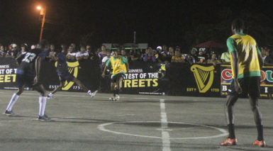 Flashback- Stellon David (centre) of Bent Street attempting to maintain possession of the ball while being challenged by Akeem Saul (left) of Holmes Street Tigerbay while  team-mates Rensford Coleridge (no. 33) and Daniel Wilson (no.17) look on during the opening elimination round at the National Cultural Centre tarmac on Monday.