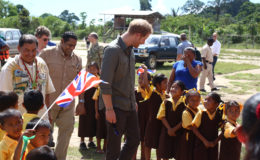 Britain’s Prince Harry charms these pupils of the Kurupukari Annex School who greeted him on his arrival at Iwokrama yesterday. See photos on centre pages. (Photo by Keno George)
