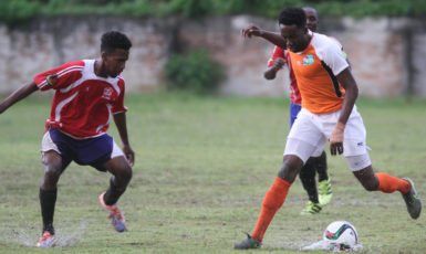 Rishawn Sandiford of Fruta Conquerors (right) trying to maintain possession of the ball while being marked closely by a Buxton United player during their matchup at the MSC ground in Linden in the GFF Stag Beer Elite League.