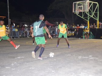 Sheldon Profitt (no.7) of Leopold Street initiating an attacking play while being watched closely by Carl Tudor (right) of North East La Penitence in the 7th Guinness ‘Greatest of the Streets’ Georgetown Zone at the Burnham Court.