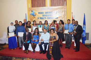 Winners of the Pan American Health Organisation/World Health Organisation (PAHO/WHO) Media Awards for Excellence in Health Journalism pose with PAHO/WHO Country Representative Dr William Adu-Krow (seated, left), Prime Minister Moses Nagamootoo (seated, second right) and Minister of Telecommunications Cathy Hughes (seated, right). 