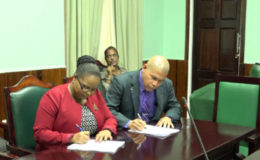 Minister of Social Protection, Volda Lawrence (left) and Minister of Public Health, Dr. George Norton, signing the National Task Force for the Prevention of Sexual Violence protocol at Parliament Building (GINA photo)
