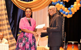 Viola Rowe, receiving the $1M cheque from President David Granger, for boosting of Science and technology subjects and facilities at the institution. . (Ministry of the Presidency photo)