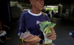 A street vendor counts bolivar notes near Venezuela’s Central Bank in Caracas, Venezuela December 16, 2016. (Reuters/Marco Bello)