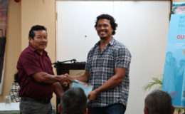 APA President, Mario Hastings (left) handing over the report to Deputy Chair of the National Toshaos Council, Lennox Shuman. 