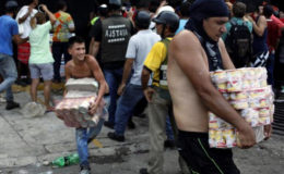 People carry goods taken from a food wholesaler after it was broken into, in La Fria, Venezuela December 17, 2016. (Reuters/Carlos Eduardo Ramirez)