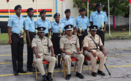 Seated from left: Assistant Commissioner of Police and Force Training Officer Paul Williams, Commissioner of Police Seelall Persaud and Assistant Superintendent of Police Bacchus pose with the most outstanding ranks for each recruit course yesterday.