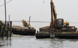 An excavator mounted on a pontoon works to desilt the Cowan Street outfall (Ministry of Public Infrastructure Photo) 