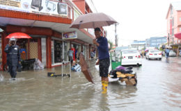 This vendor used the flood as an opportunity to sell his long boots and umbrellas on Regent and King streets yesterday. 