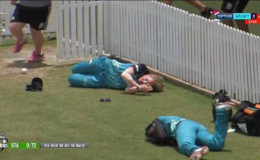 Deandra Dottin (bottom of photo) and Laura Harris lie just beyond the boundary at Allan Border Field, following their on-field collision.