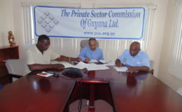 From left signing the letter are Lincoln Lewis of the TUC, Eddie Boyer of the PSC and Kenneth Joseph of FITUG.